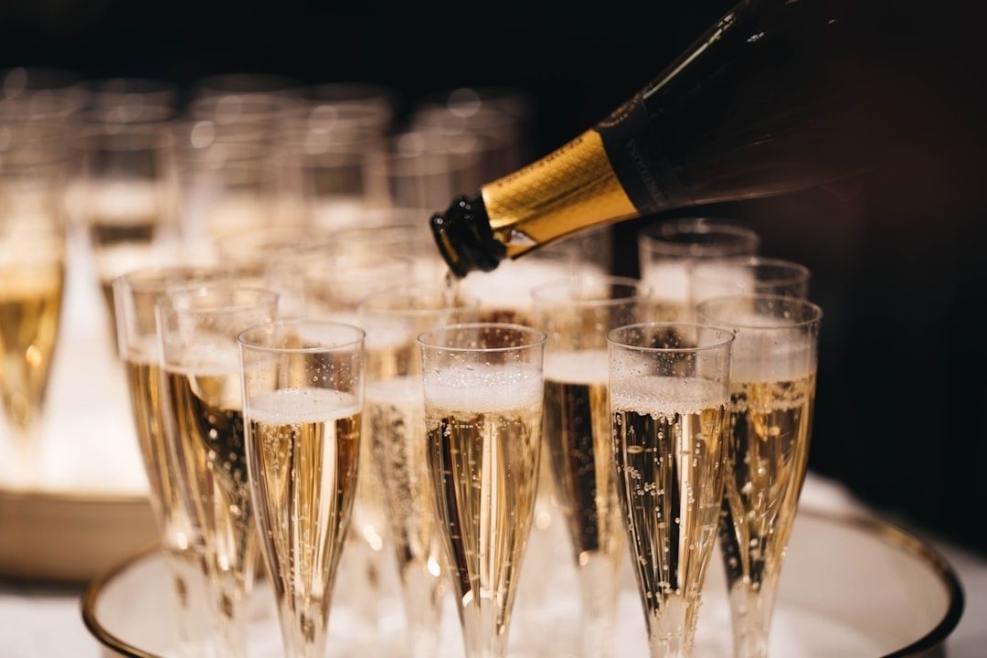 Bouteille de vin effervescent versant dans des flûtes remplies de bulles