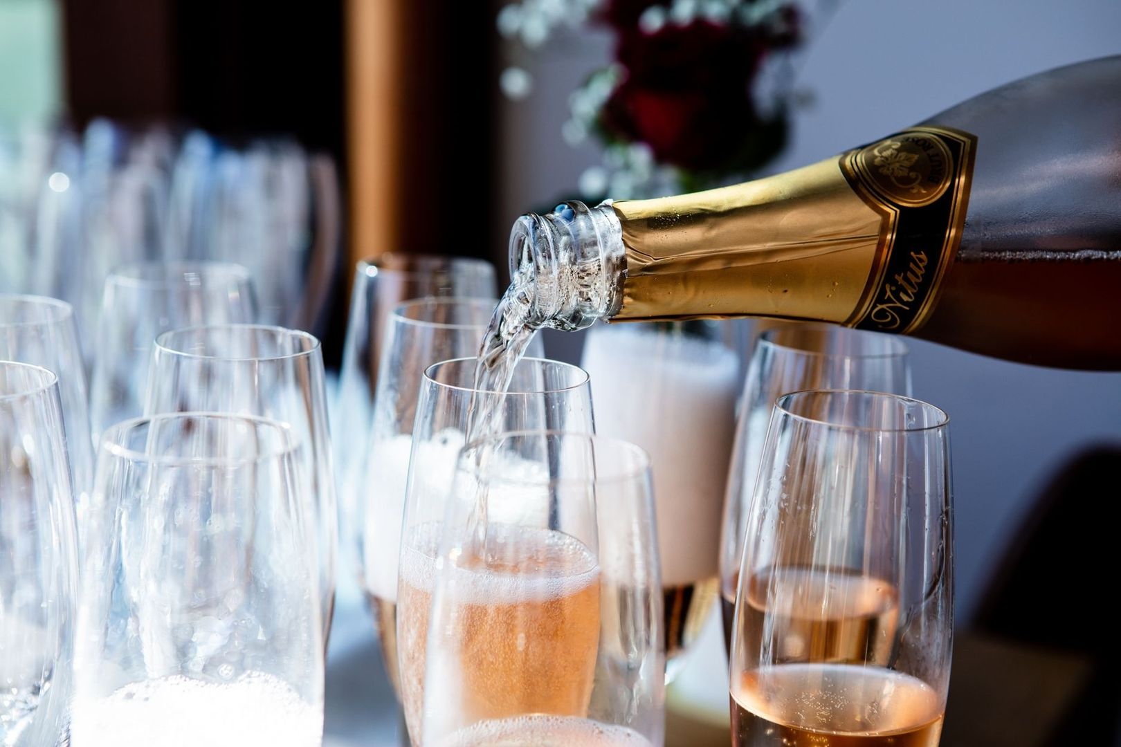 Bouteille de vin effervescent versant dans des flûtes à champagne