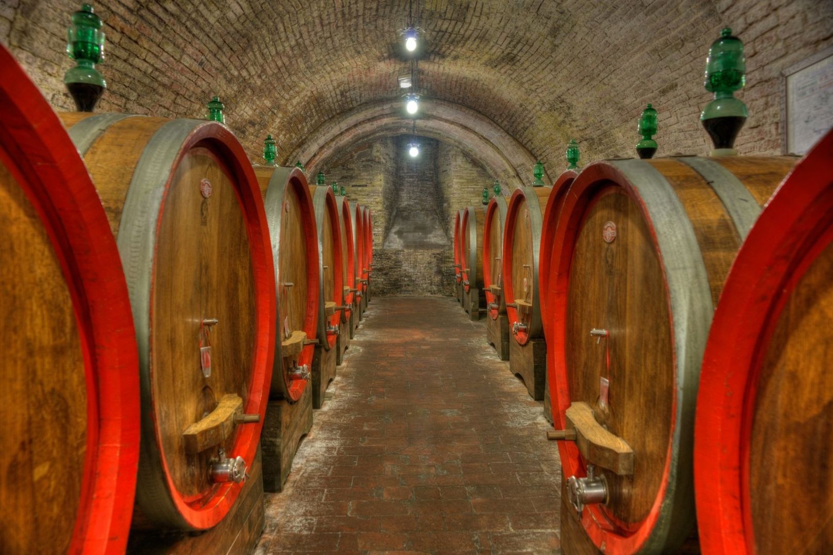 Fûts en bois alignés dans une ancienne cave voûtée